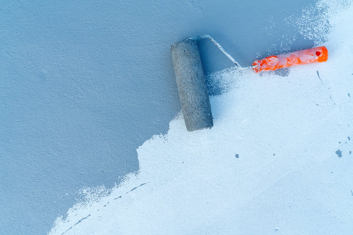 Paint roller applying paint to a wall